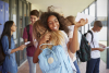 Teenage students celebrating exam results in school corridor